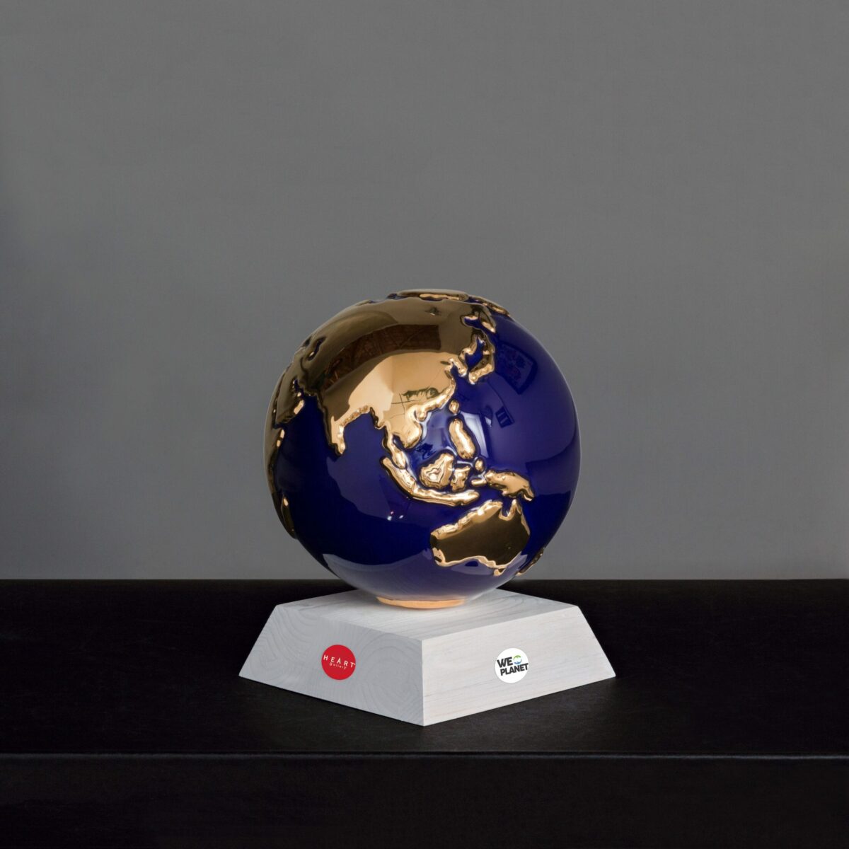 sfera in ceramica blu rappresentante il pianeta terra con i continenti smaltati in oro