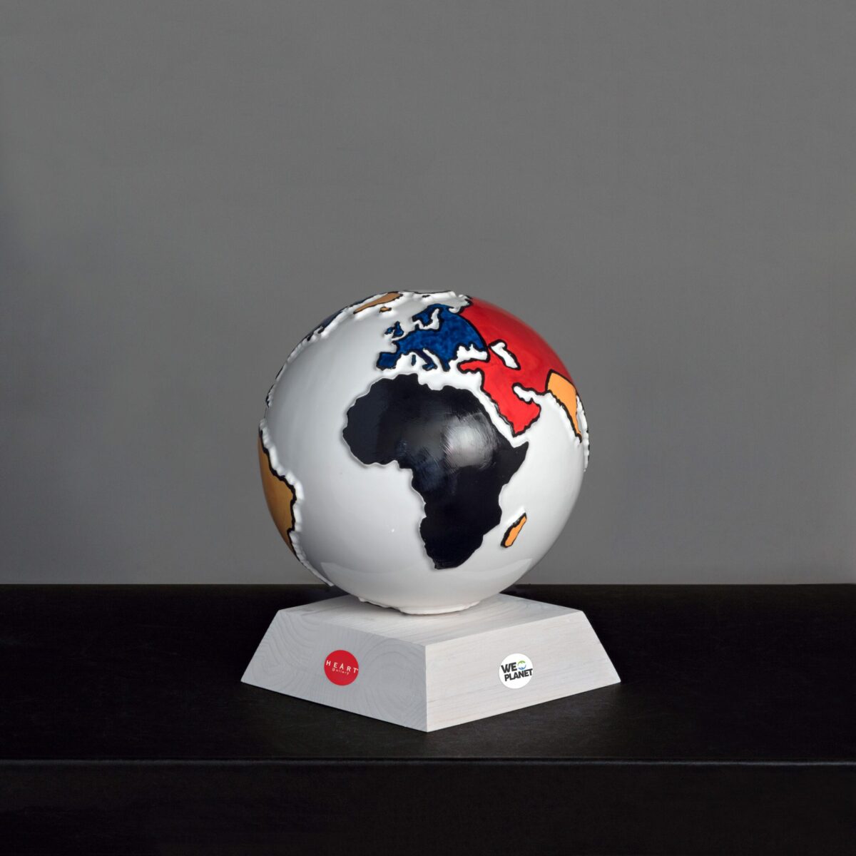mappamondo in ceramica bianco con i continenti colorati in rosso, giallo, blu e nero secondo lo stile Mondrian