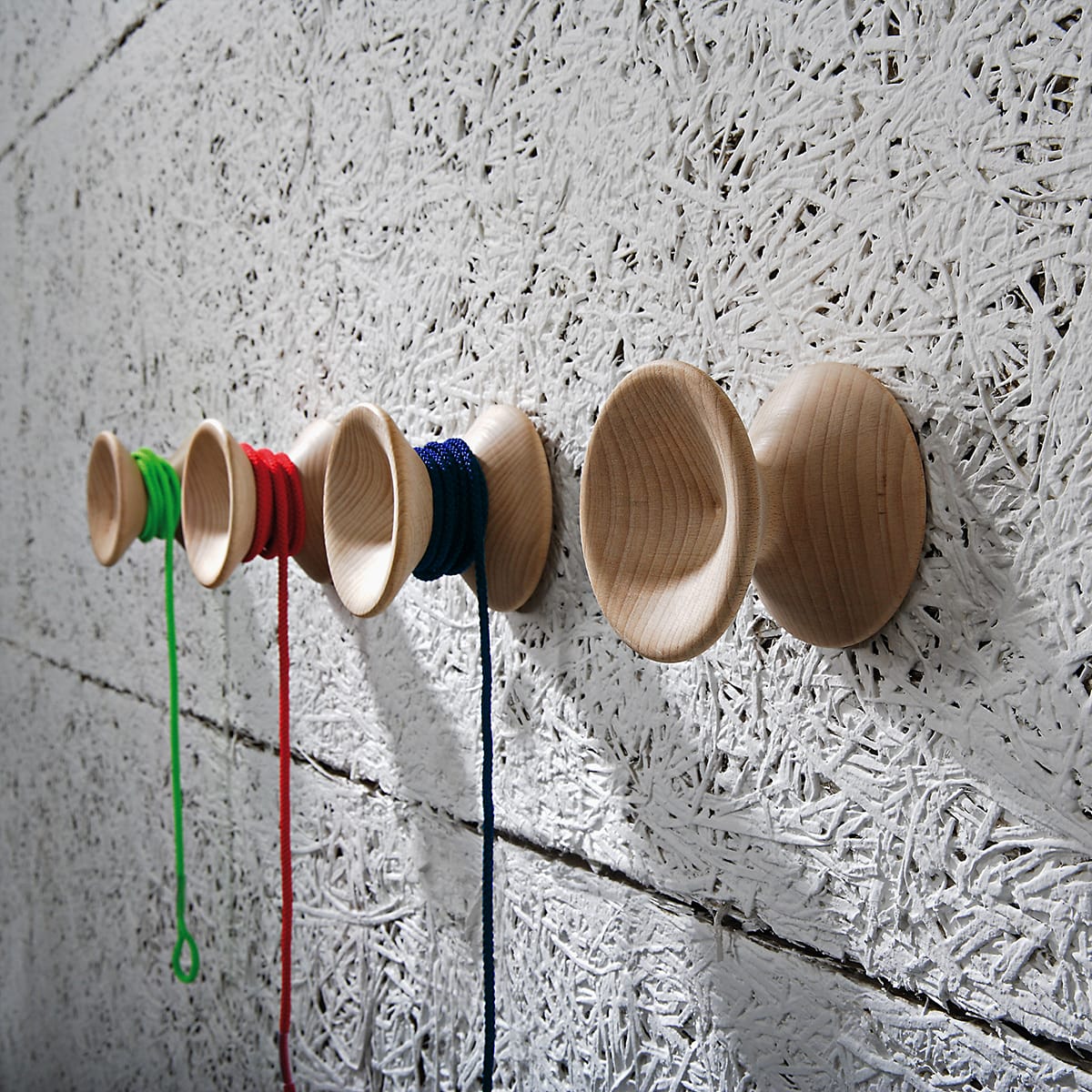 pomelli appendiabiti in legno chiaro a forma di yo yo con cordoncino colorato