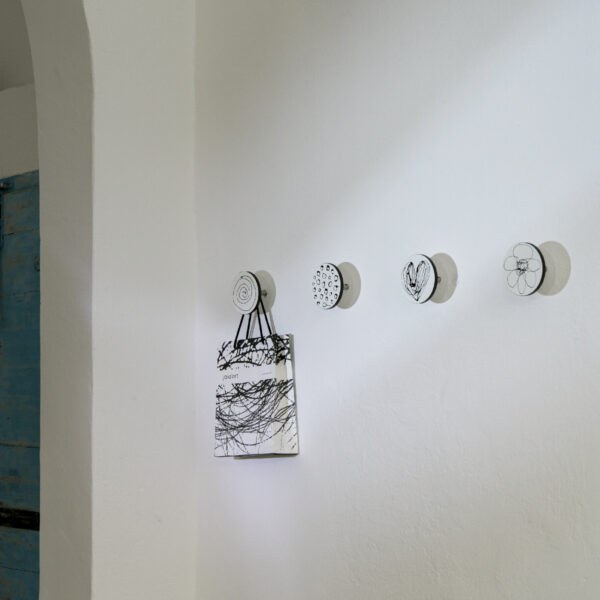 dischi appendiabiti appesi su un muro bianco