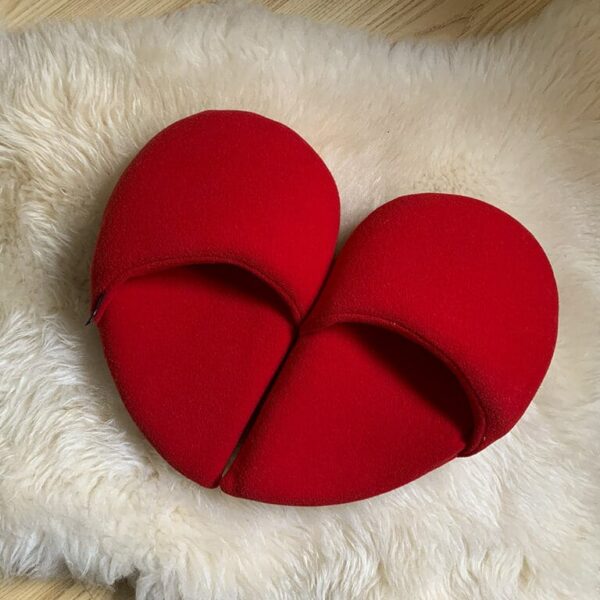 ciabatte realizzate in pile rosso, unite formano un cuore, ogni piede calza mezzo cuore