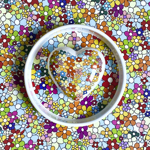 una texture di margherite colorate stilizzate è elemento decorativo di un cuore in ceramica e una ciotola bassa
