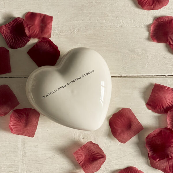 cuore per innamorati, scritta poetica su cuore in ceramica bianca tra i petali di rosa rossa