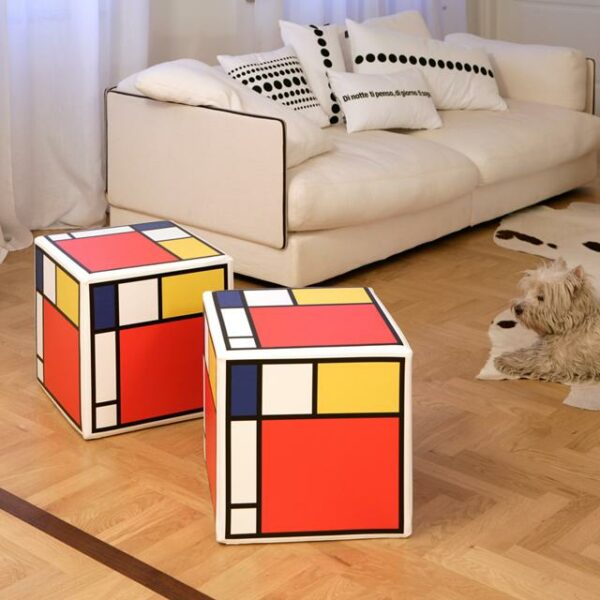 due pouf a cubo rigidi con stampa ispirazione Mondrian su ogni lato con il rosso colore dominante seguito dal giallo, blu e bianco, nero