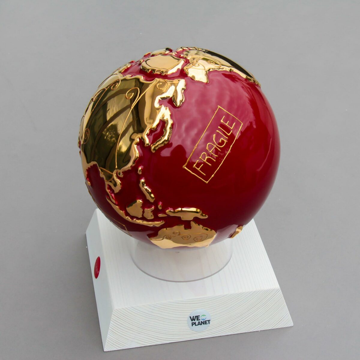 globo in ceramica rosso rappresentante la terra con la scritta "Fragile" dorata