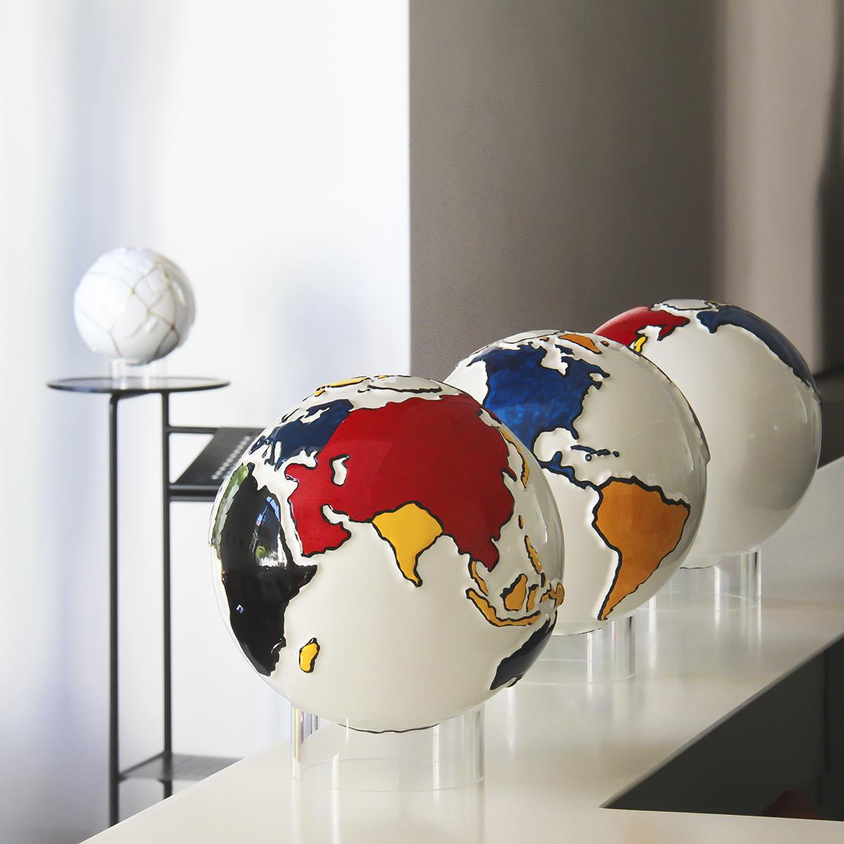 un globo in ceramica bianco rappresenta la terra e le terre emerse sono dipinte secondo lo stile Mondrian