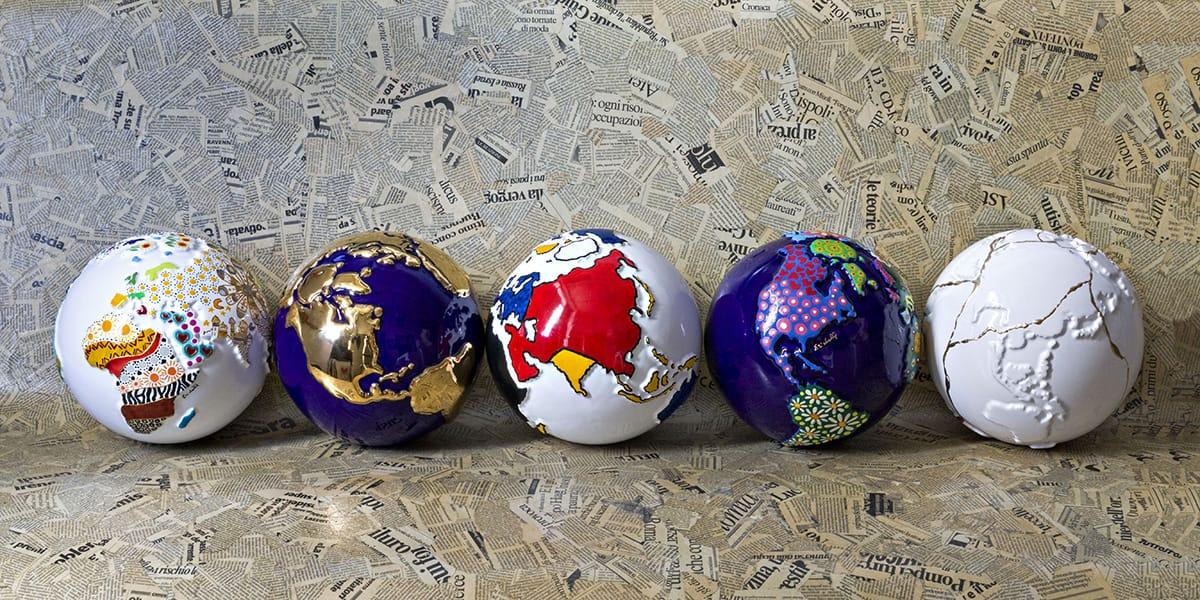 5 globi in ceramica raffiguranti la terra decorati artisticamente in stili diversi