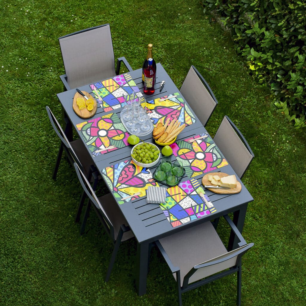 tavolo estivo apparecchiato con tovagliette americane quadrate con le stampe di Romero Britto