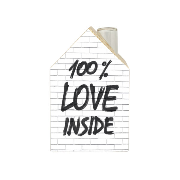 100% love inside è un murals scritto sulla facciata di mattoni bianchi di una casetta in legno, elemento decorativo e vaso monofiore