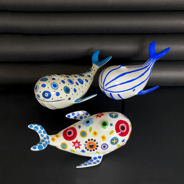 un trio di balene decorative in ceramica
