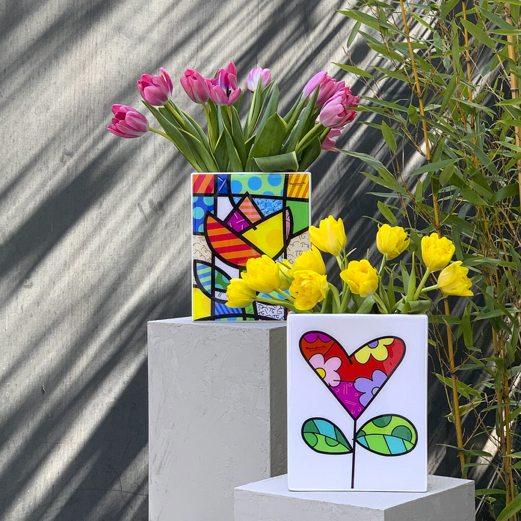 vasi in ceramica decorati con le opere grafiche di Romero Britto con alcuni tulipani colorati e posti su alcuni piedistalli